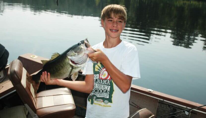 Young bass fisherman with his bass catch